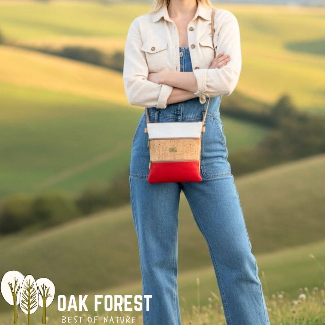 Femme portant le sac bandoulière Trilogia en liège blanc, naturel et rouge sur une salopette en jean