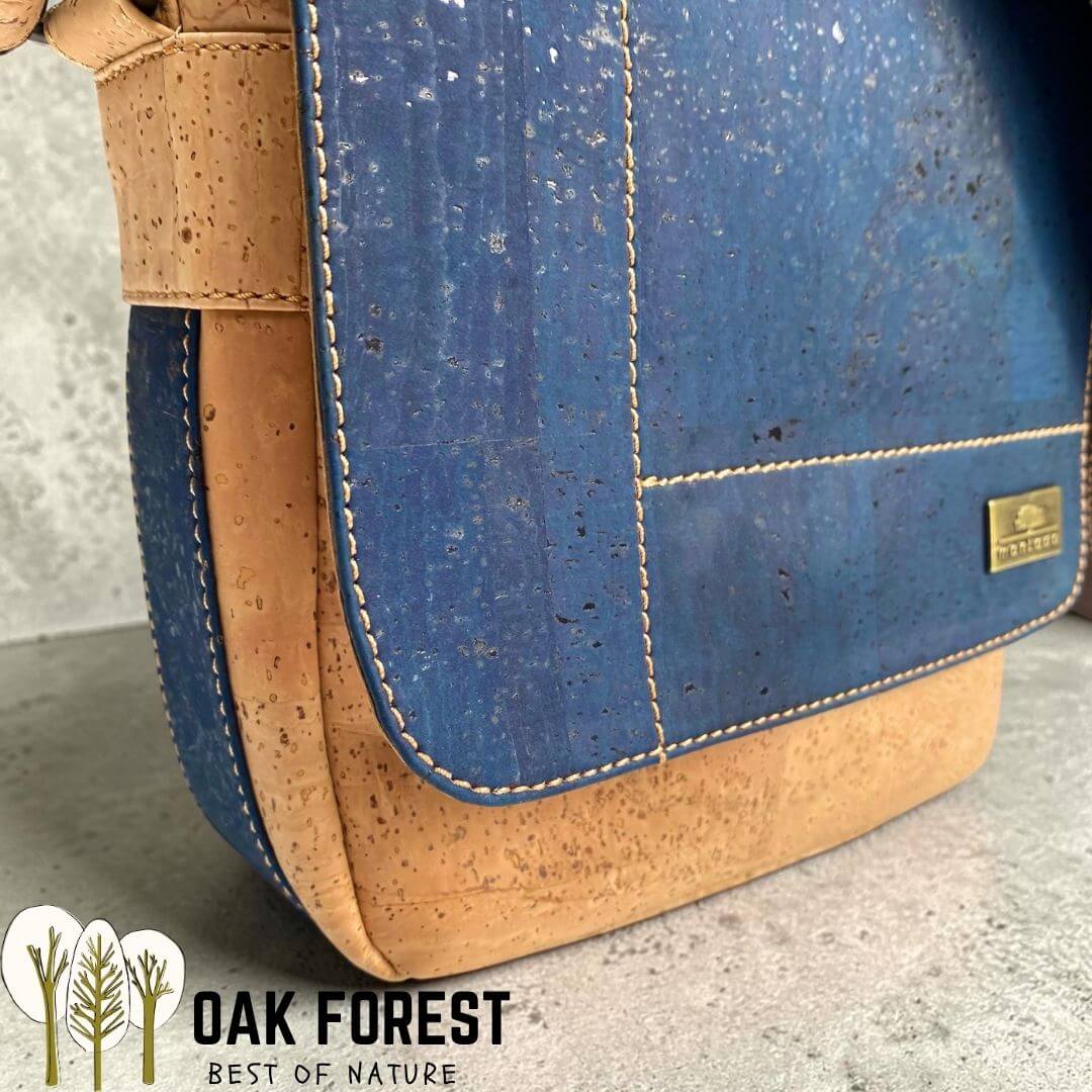 Gros plan sur Sacoche homme Navigator en liège bleu marine et naturel, avec rabat aimanté et surpiqûres blanches