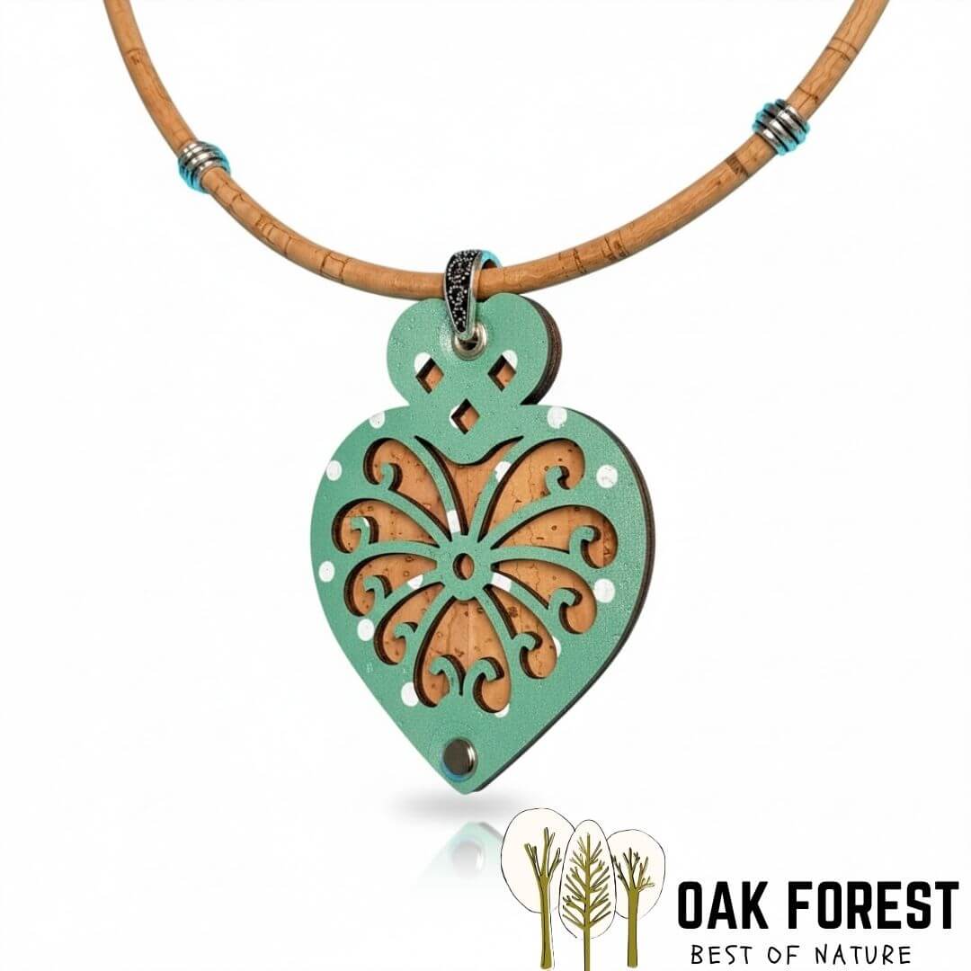 Détail du pendentif coeur en liège ajouré vert d'eau, motif floral découpé laissant apparaître le liège naturel