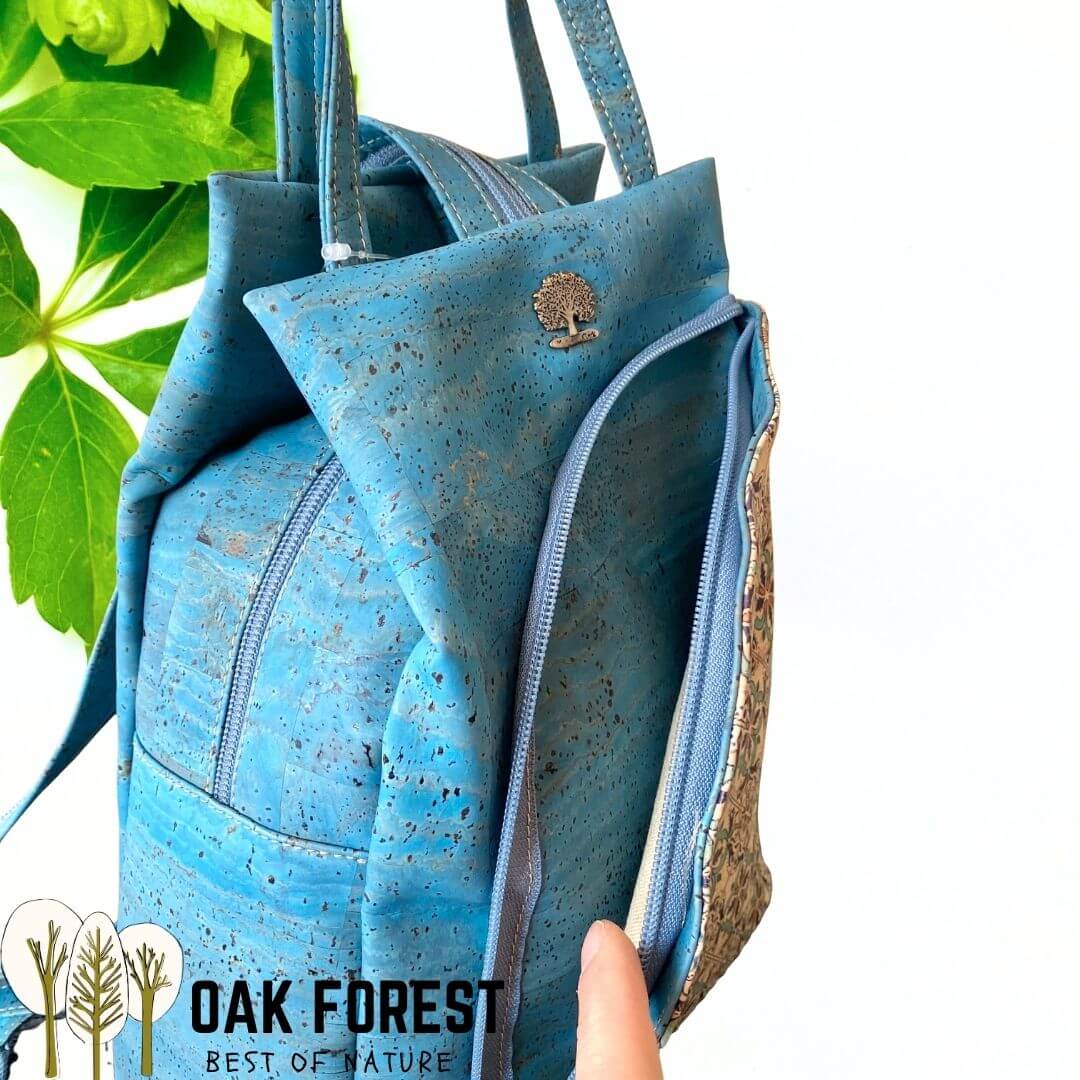 Détail du zip d'ouverture et de la texture liège bleu moucheté du sac Lisboa avec pin arbre doré
